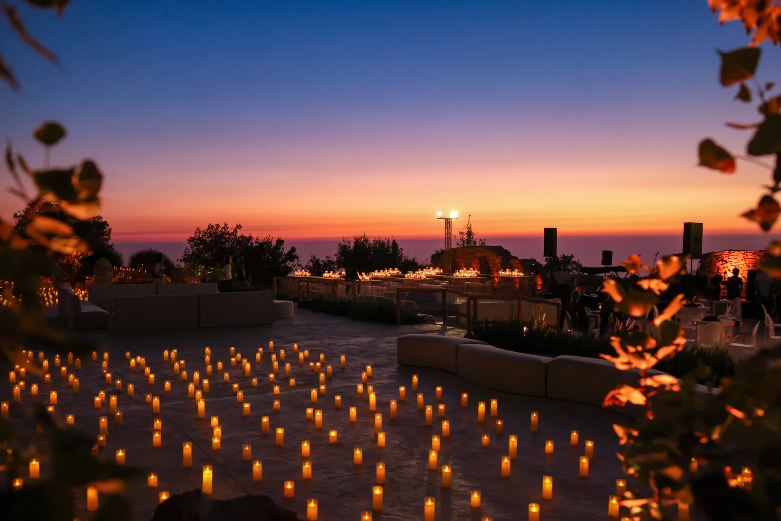 Rows of glowing candles on the 1000M terrace beneath a pink and orange sky at the launch