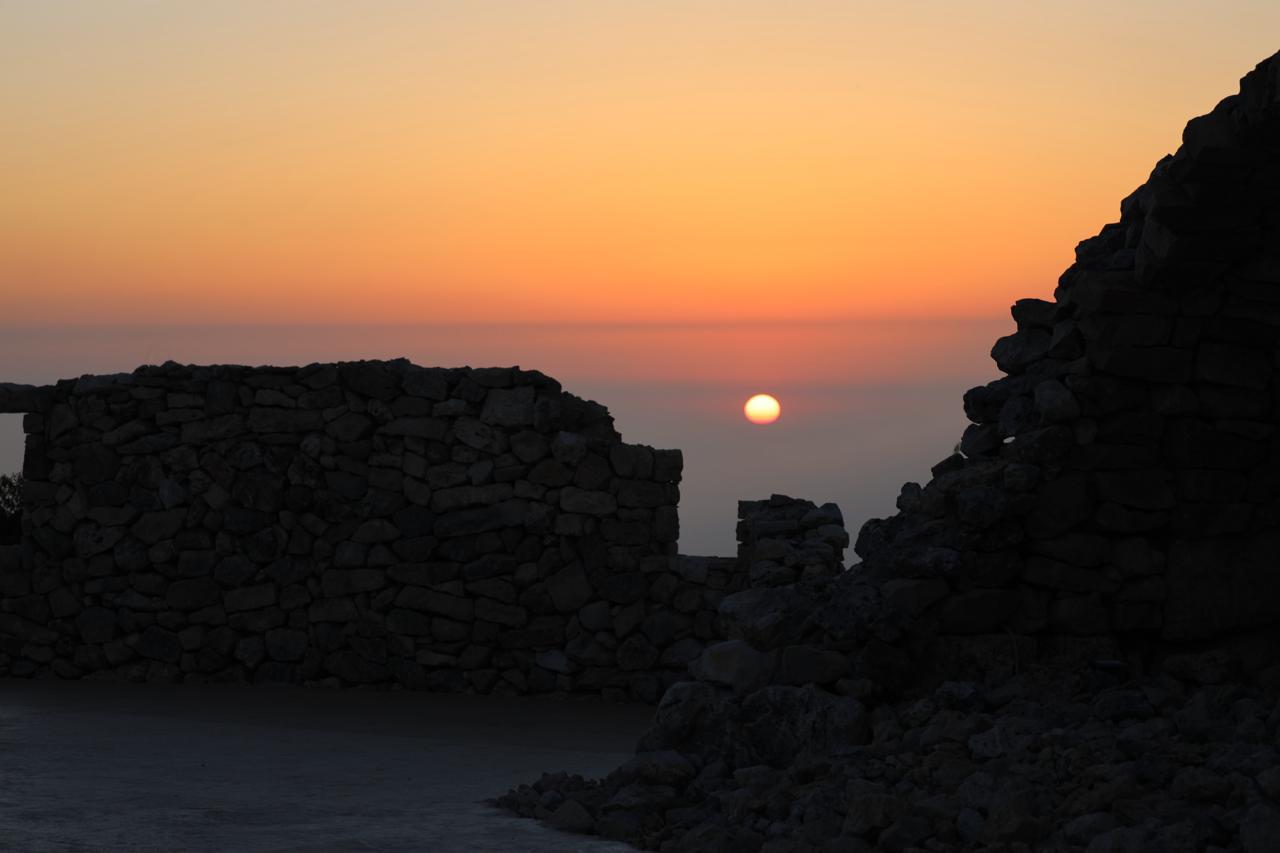 Sunset over the stone ruins beside the terrace