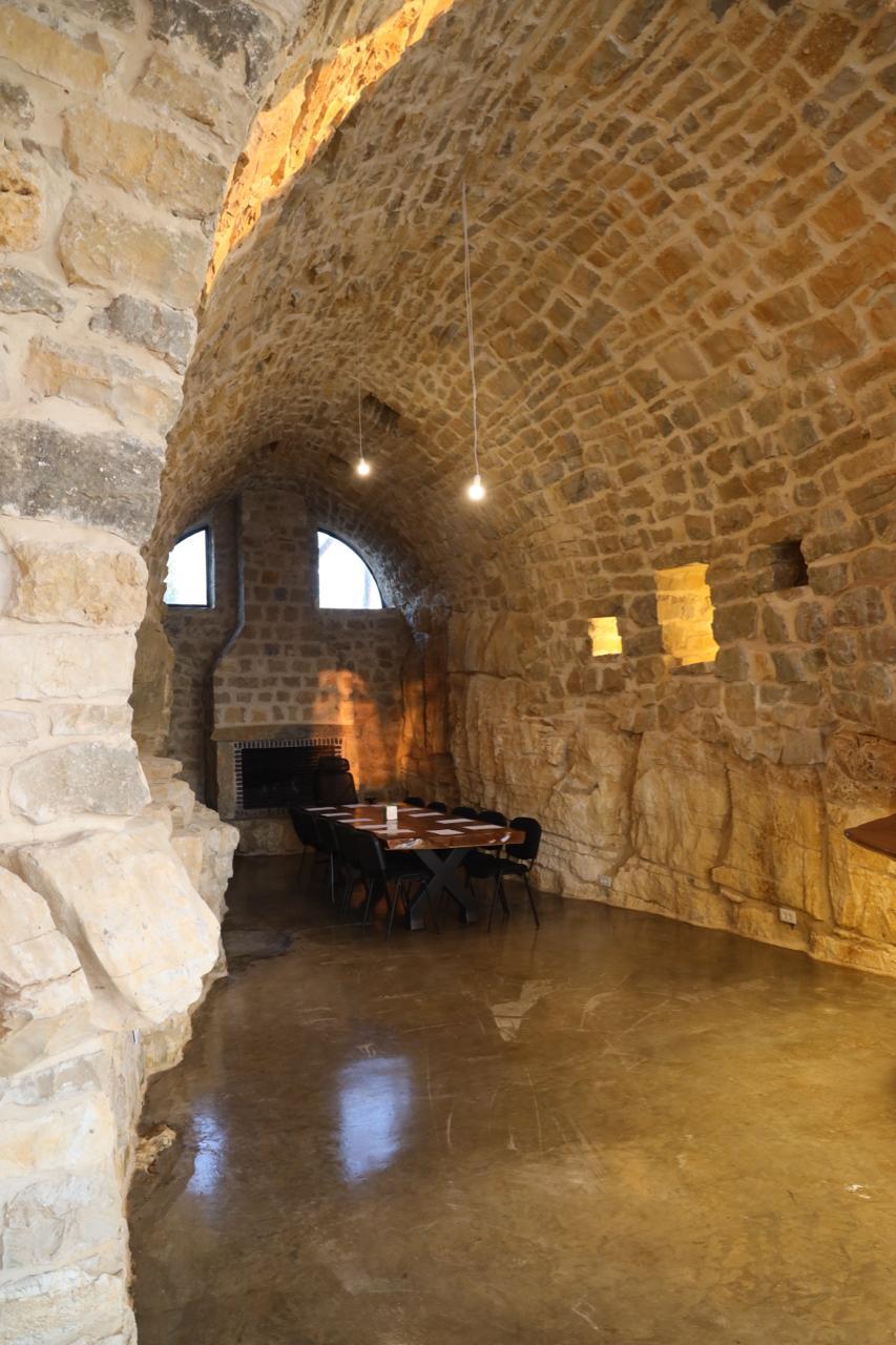 Vaulted stone dining room with a fireplace and long wooden table