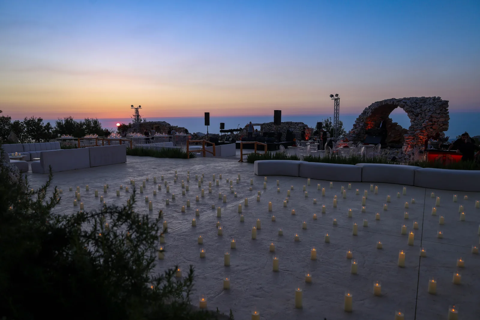 Candles arranged across the terrace beside the stone ruins at 1000M at dusk