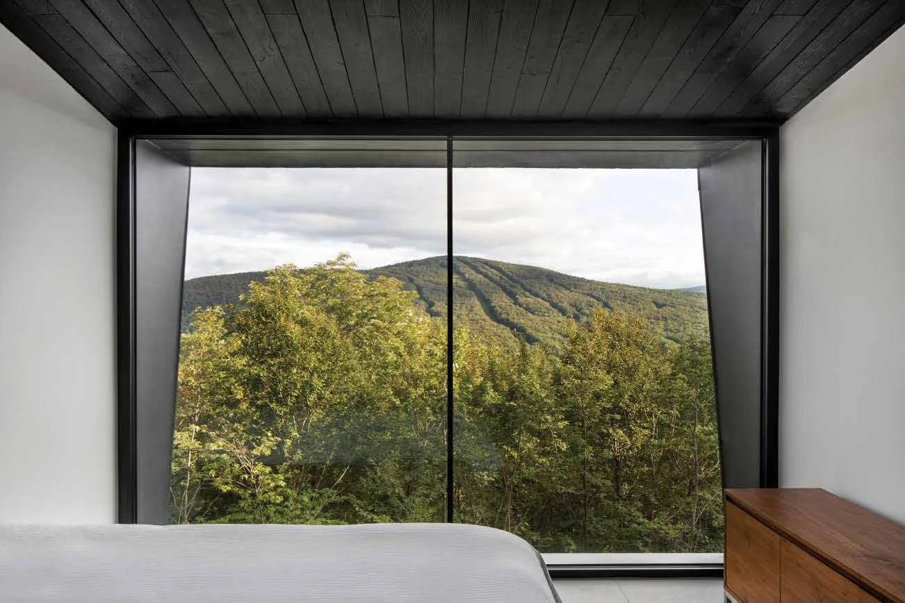 Architectural reference showing a wide window facing a wooded mountain